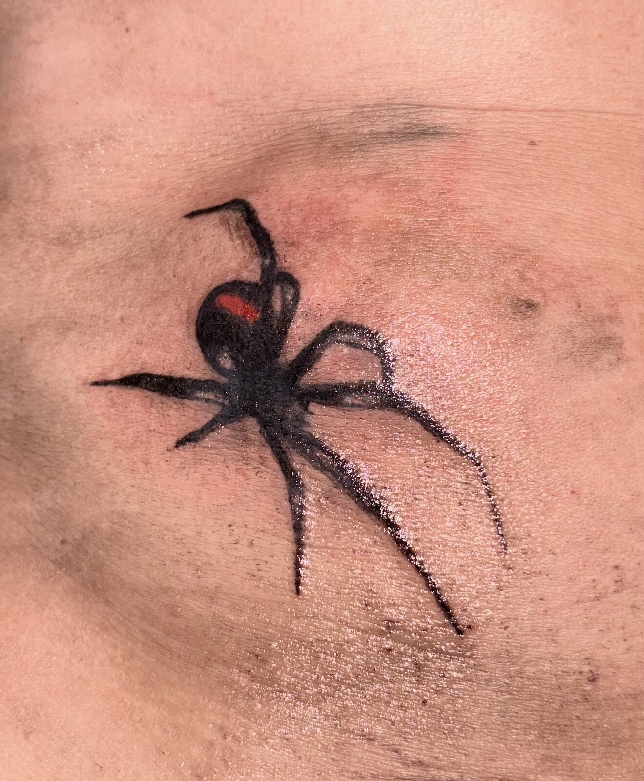 Realistic black widow spider chest tattoo